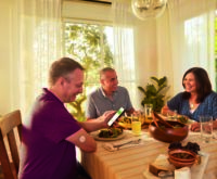 A family at dining table eating and conversing together.